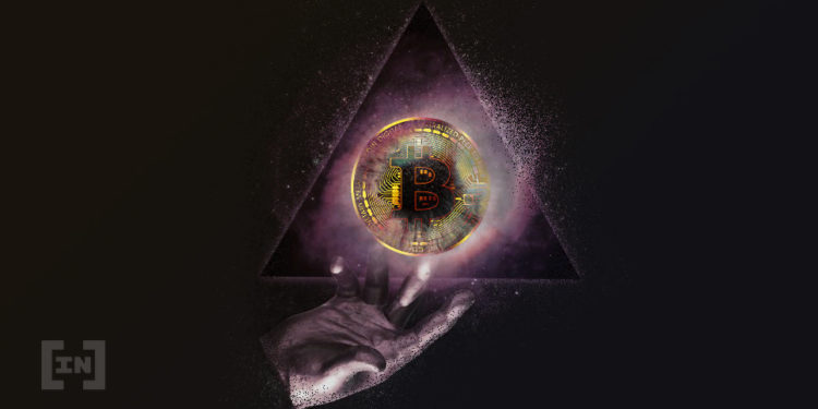 Hand hält eine dunkle Bitcoin Münze