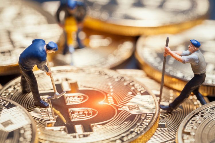 Bitcoin Miner mit Spitzhacken auf einer Bitcoin Münze
