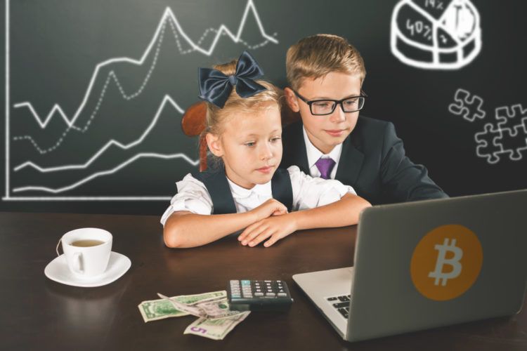 Zwei kleine Kinder vor einem Laptop mit Bitcoin Aufkleber